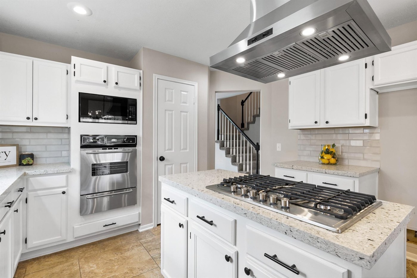 Kitchen renovation with white cabinetry, black hardware, and stainless appliances