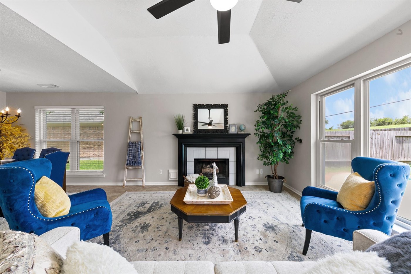 Refreshed living room with dark fireplace surround, bright walls, and updated finishes