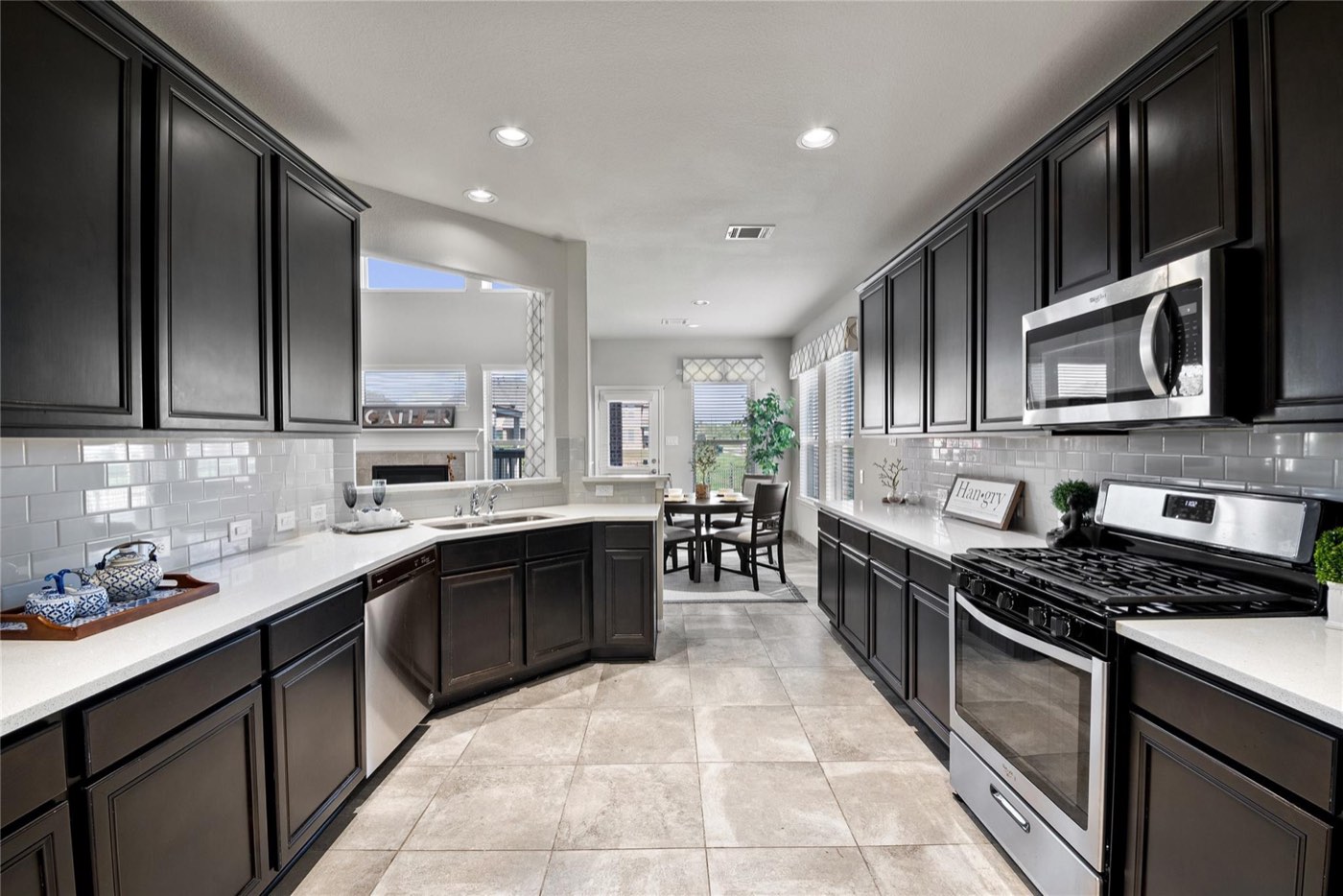Kitchen update with dark cabinetry, white counters, and subway-tile backsplash